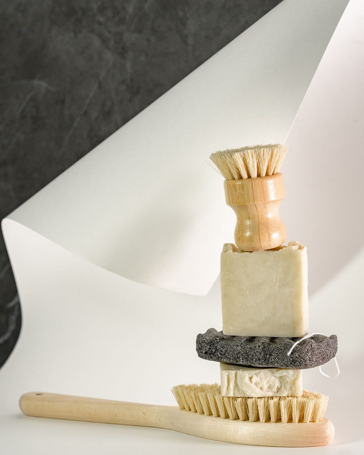 bathroom brushes, soap and a pumice stone on a white surface