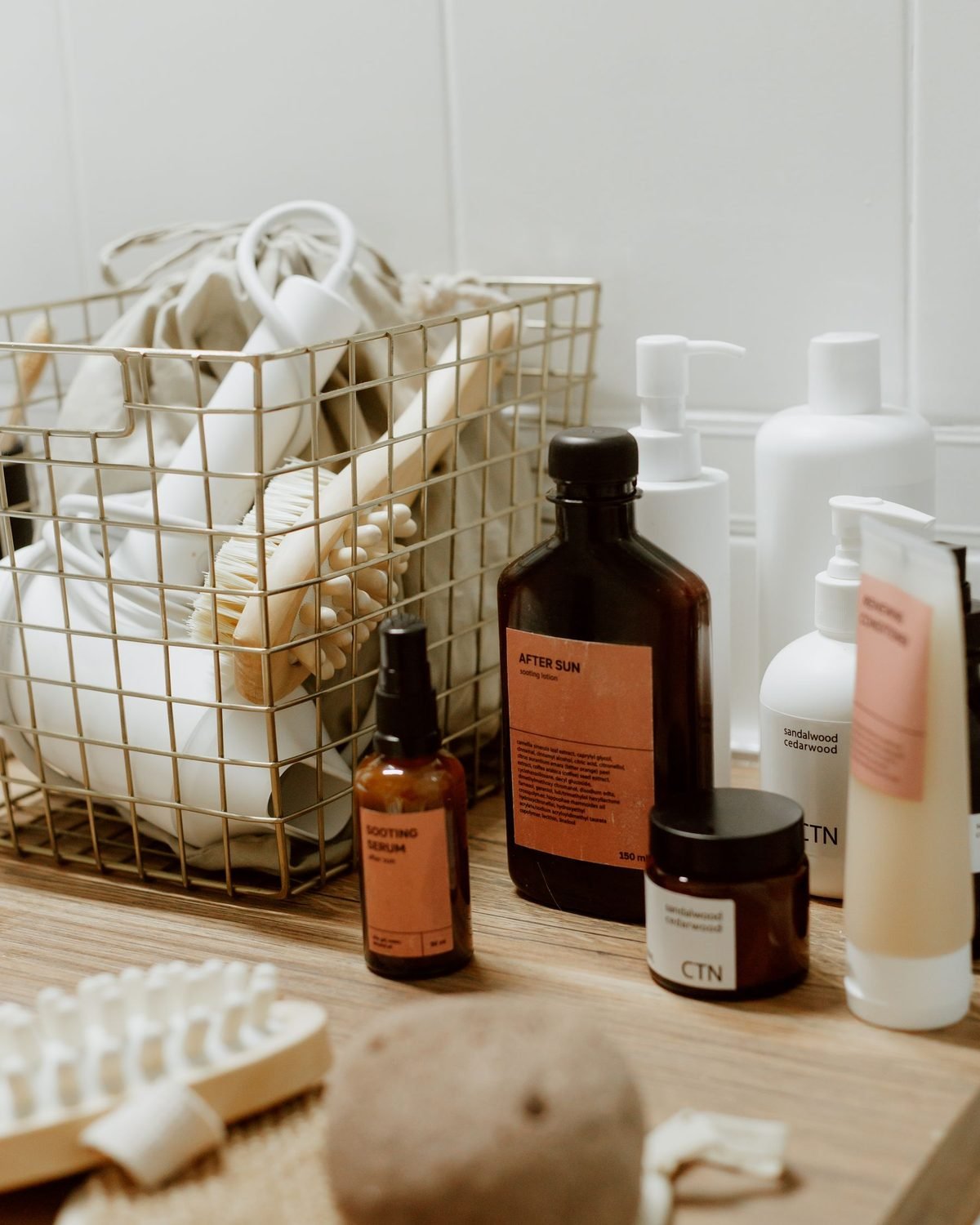 bathroom corner with skincare bottles and a woven basket
