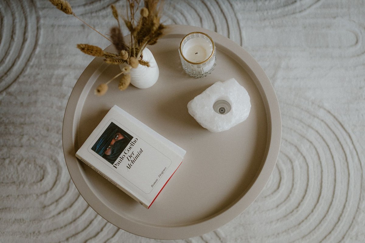 Coffee table styled with a book, candle and dried plants