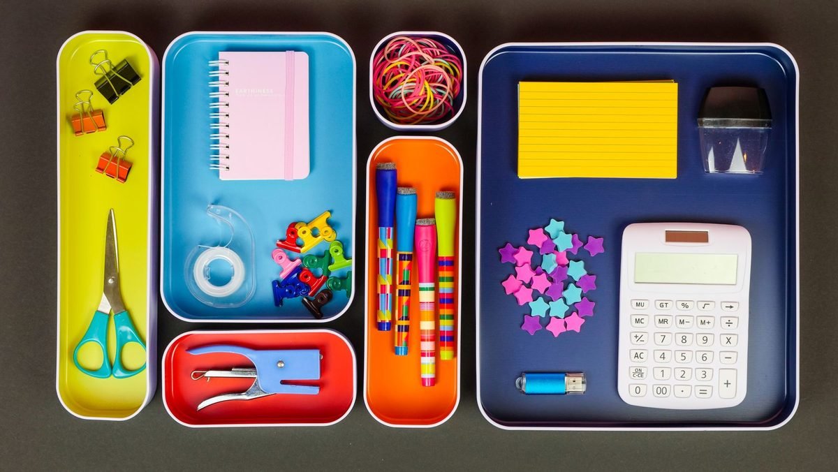 colorful desk organizer trays holding pens, scissors and stationery