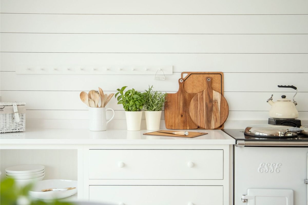 cutting boards and potted herbs on a white kitchen counter