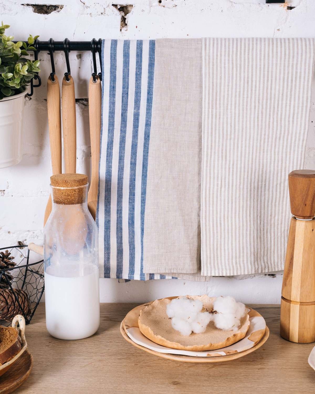 dish towel hanging beside a wooden board and kitchen utensils on a counter