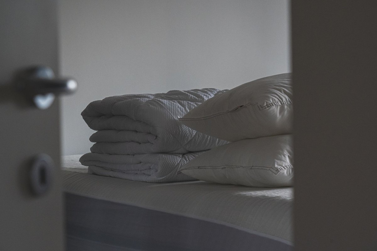 Folded blankets and stacked pillows on a bed
