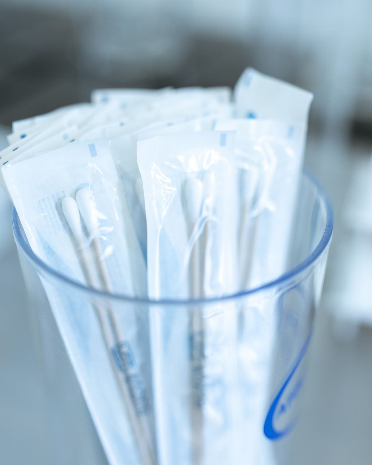 glass jar filled with cotton swabs on a bathroom counter