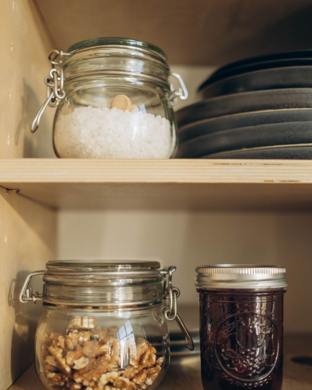 glass jars of flour, nuts and grains on cabinet shelves