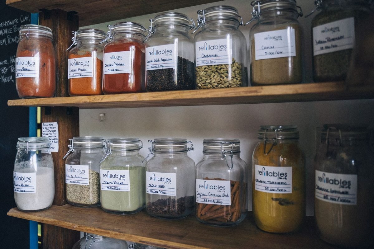 glass jars with labels on wooden shelves