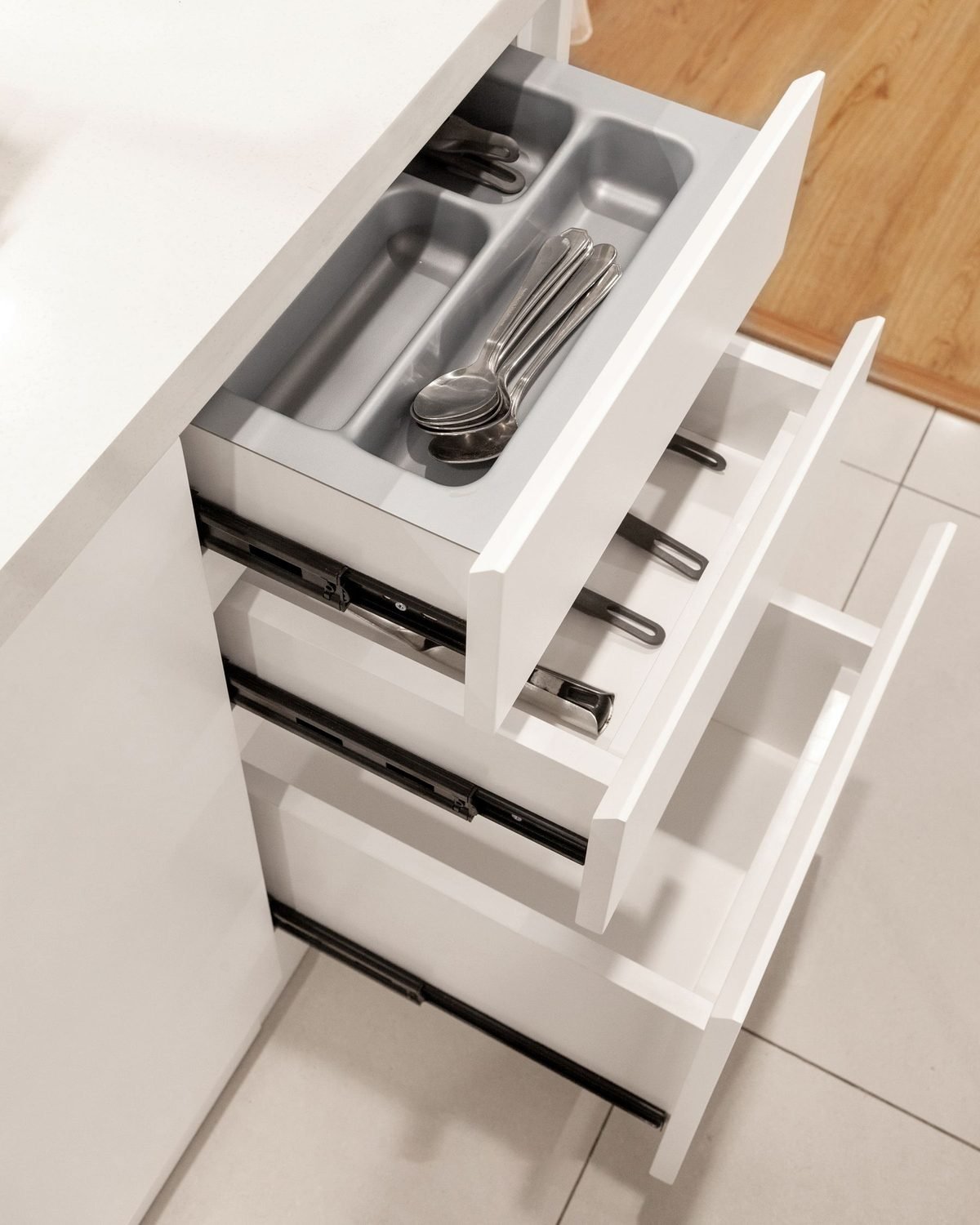 gray utensil organizer inside an open kitchen drawer