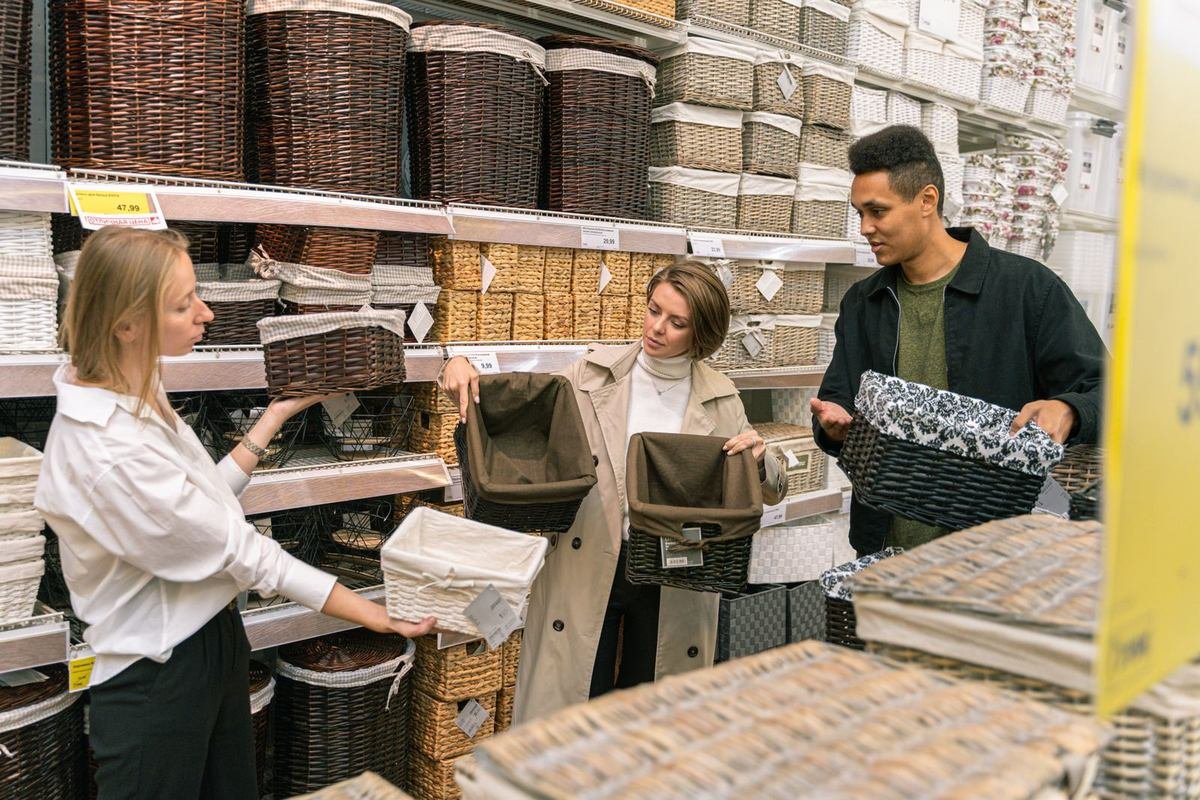 group of shoppers choosing wicker baskets in a store aisle