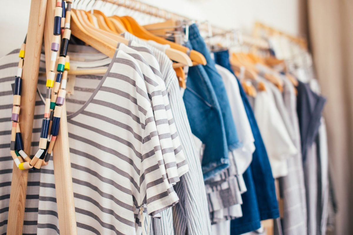 clothes on matching wooden hangers in an organized wardrobe