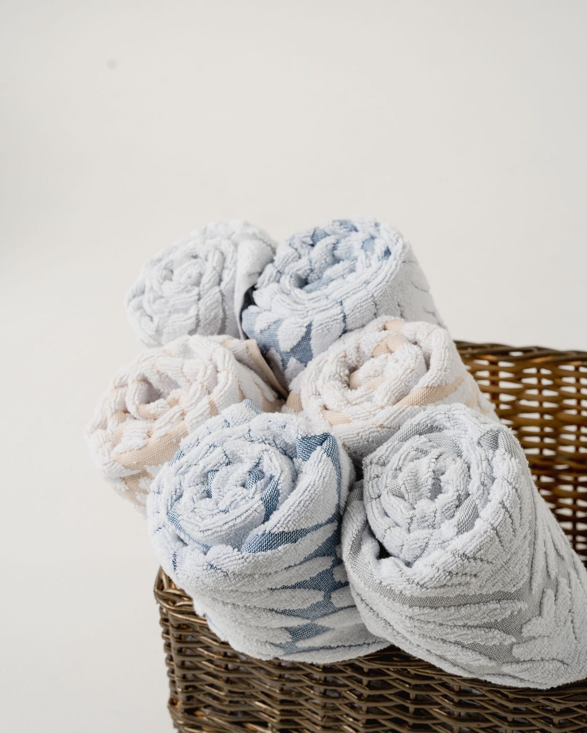 rolled towels stored in a wicker basket