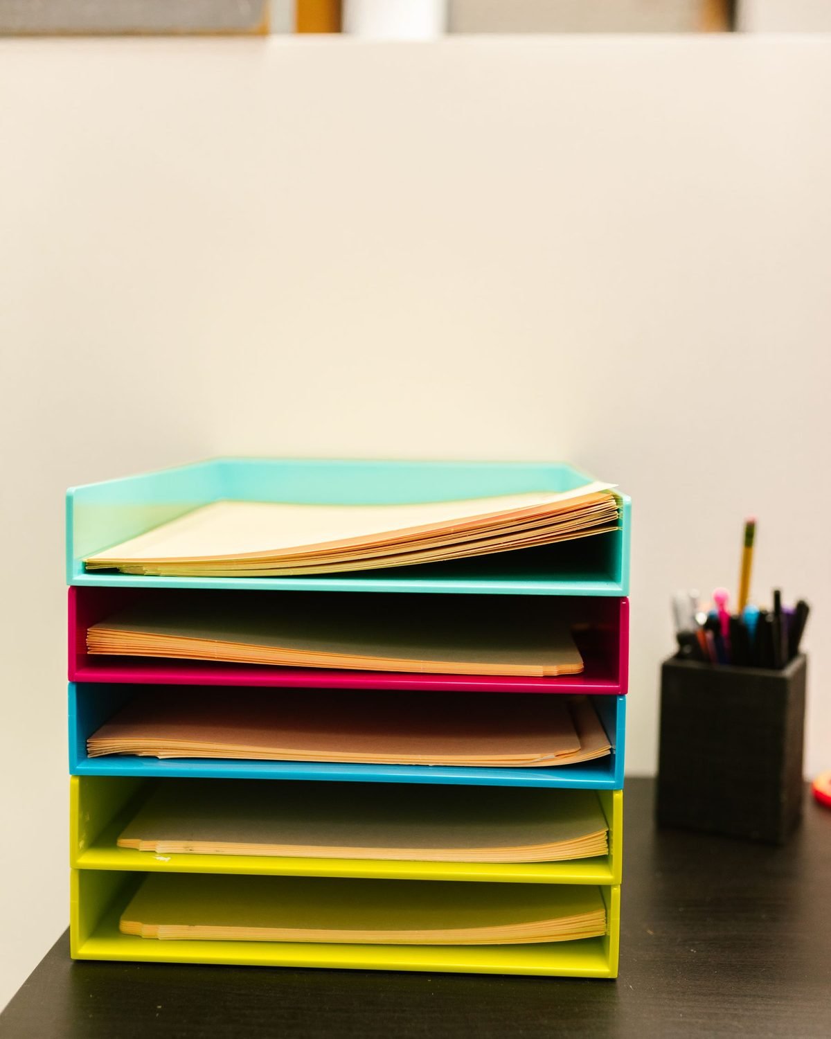 stacked paper trays holding documents on a desk