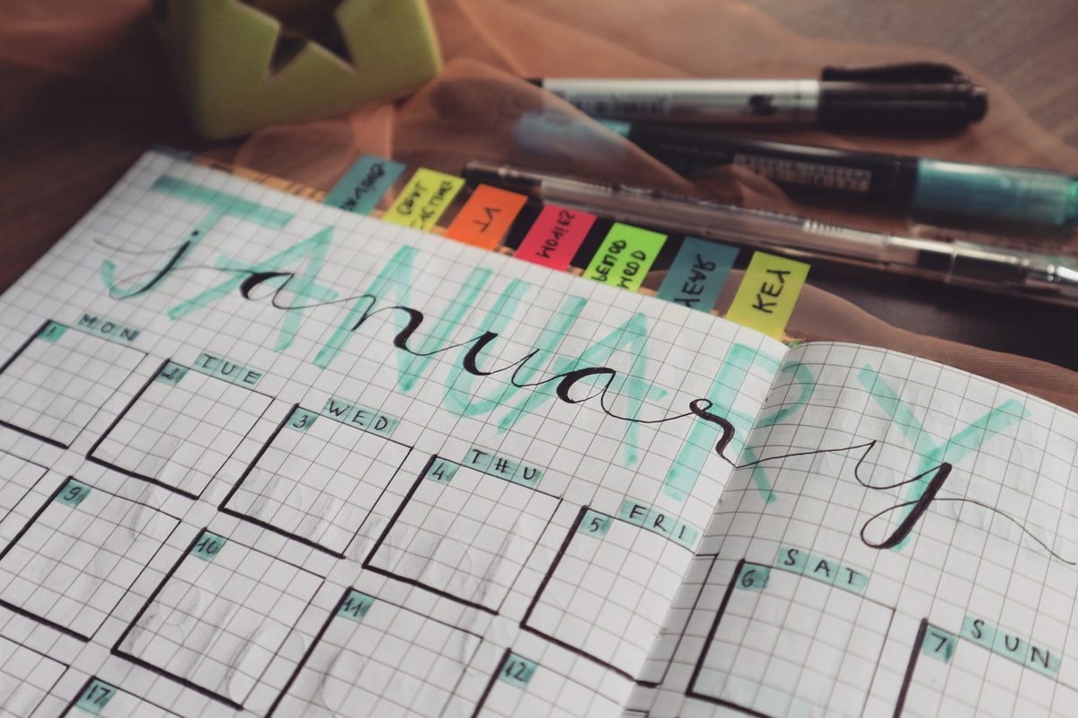 handwritten january planner page with colorful tabs and pens