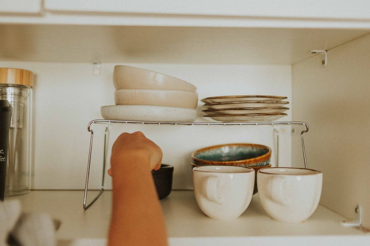 kitchen cabinet with stacked dishes and bowls on shelves