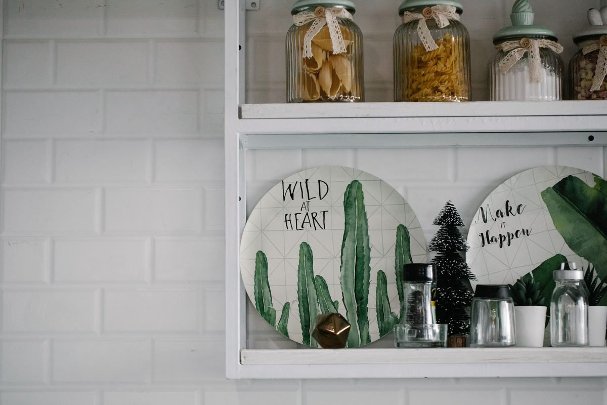 labeled glass jars and canisters on a white kitchen shelf