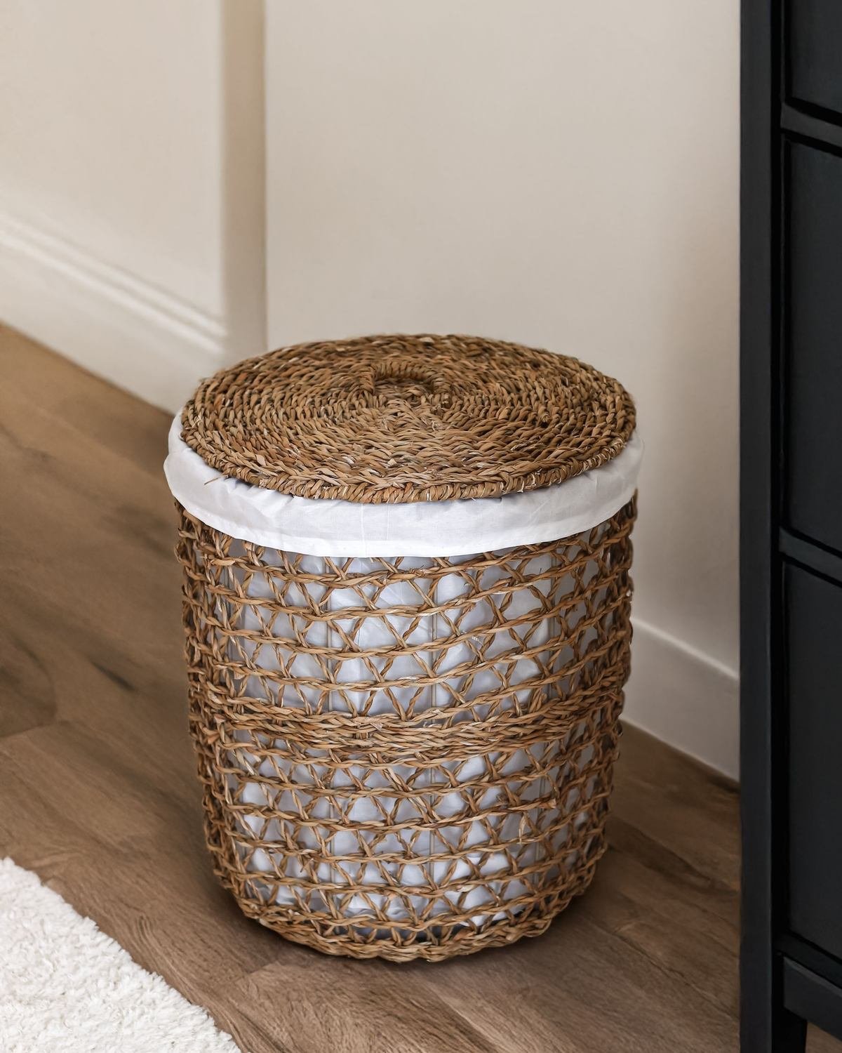 lidded wicker storage basket on the floor of a small room