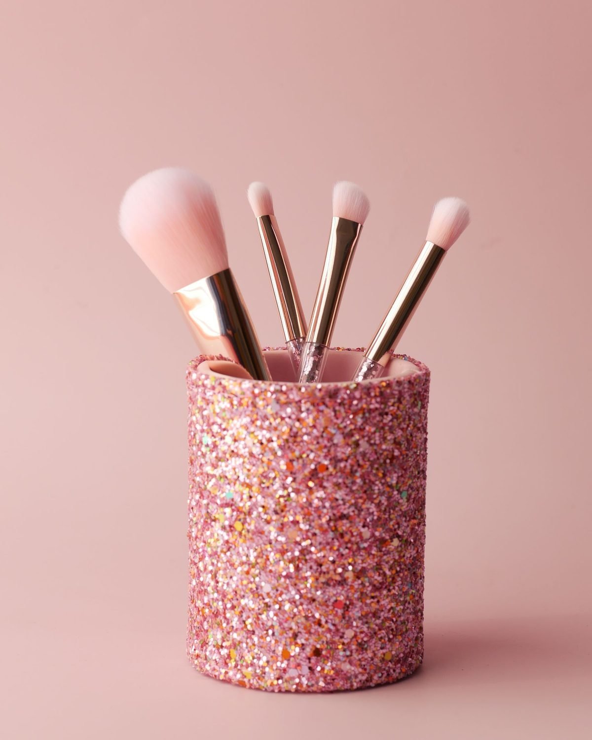 makeup brushes standing upright in a cup