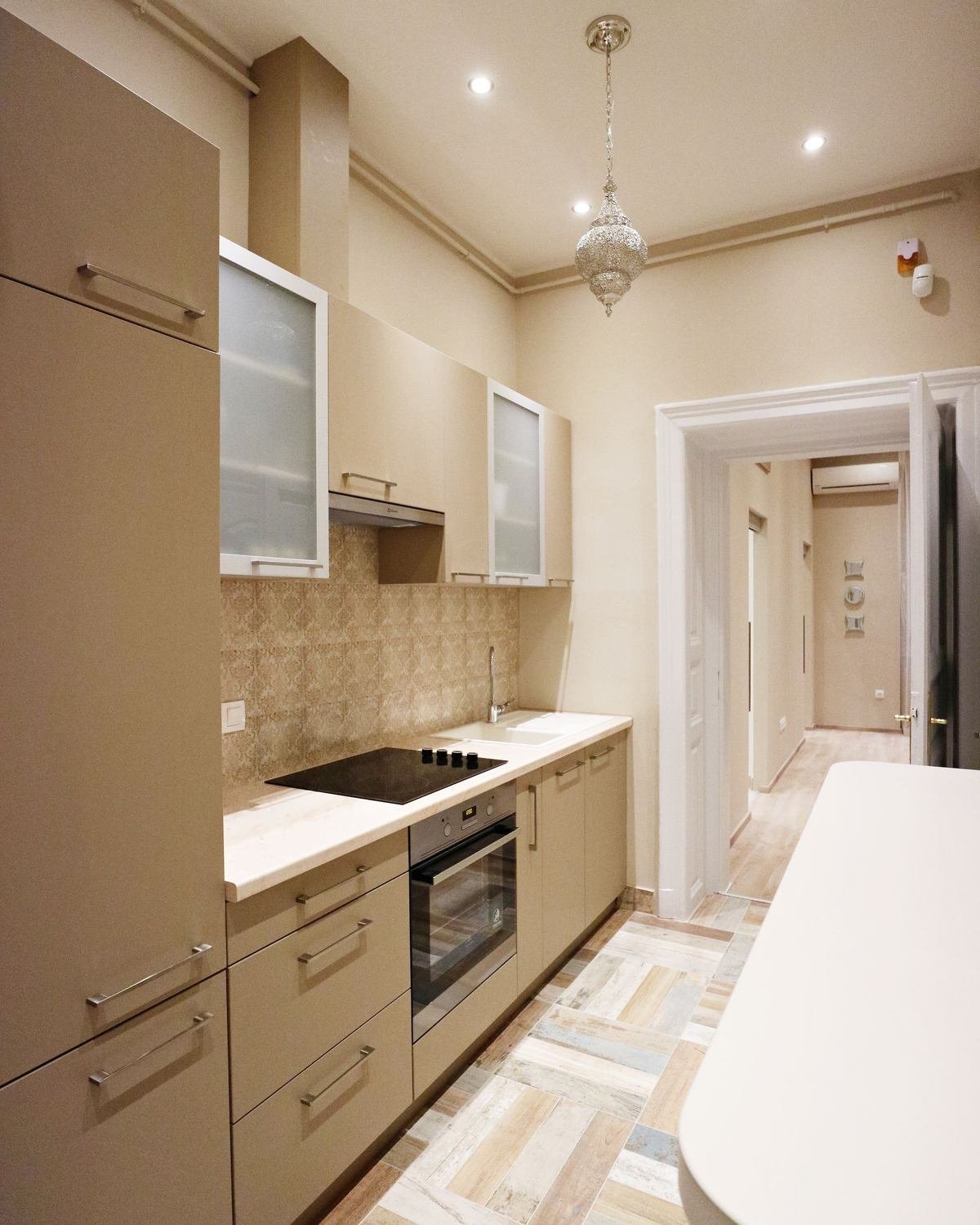 narrow modern beige kitchen with tidy counters and cabinets
