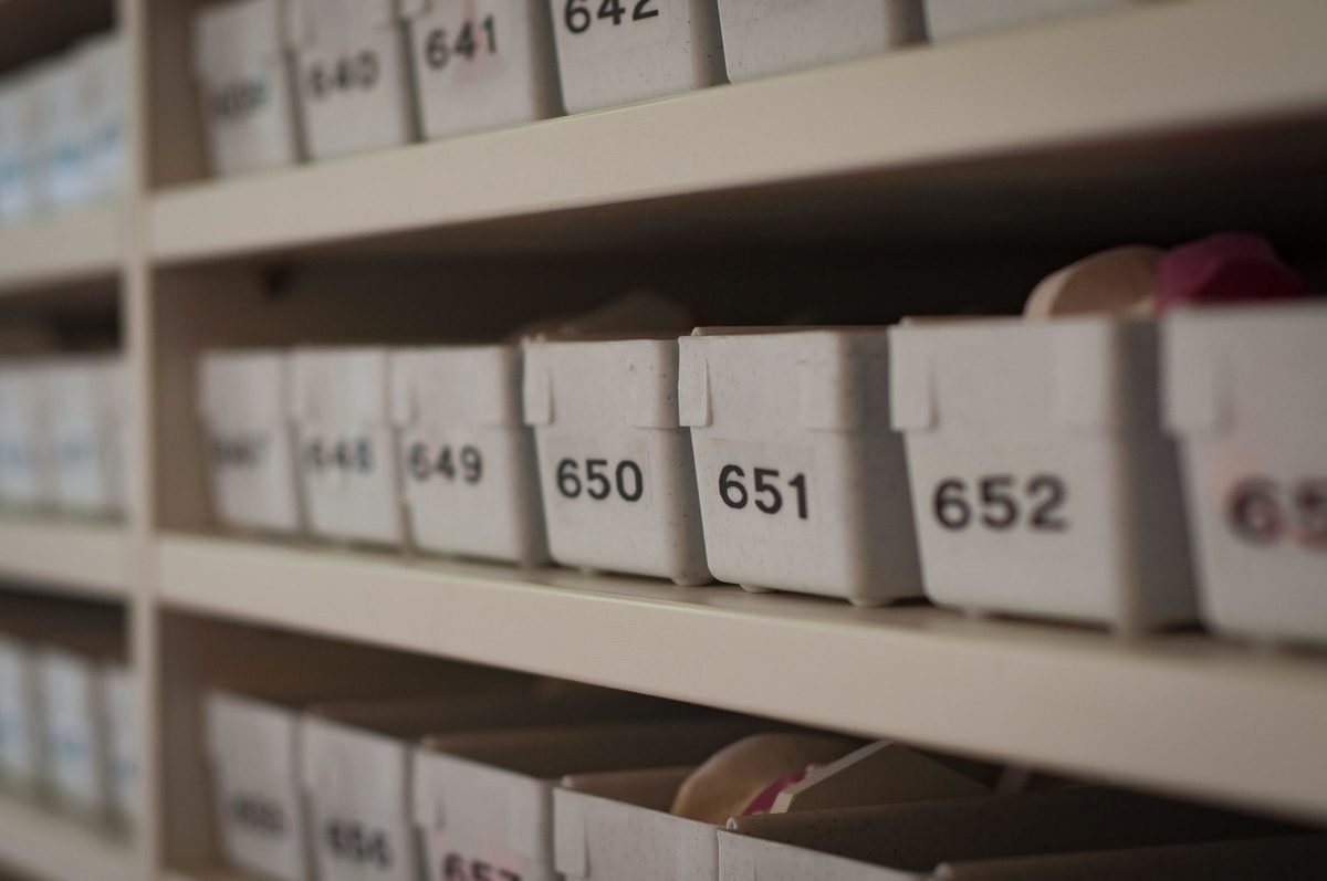 numbered and labeled storage containers lined up on shelves