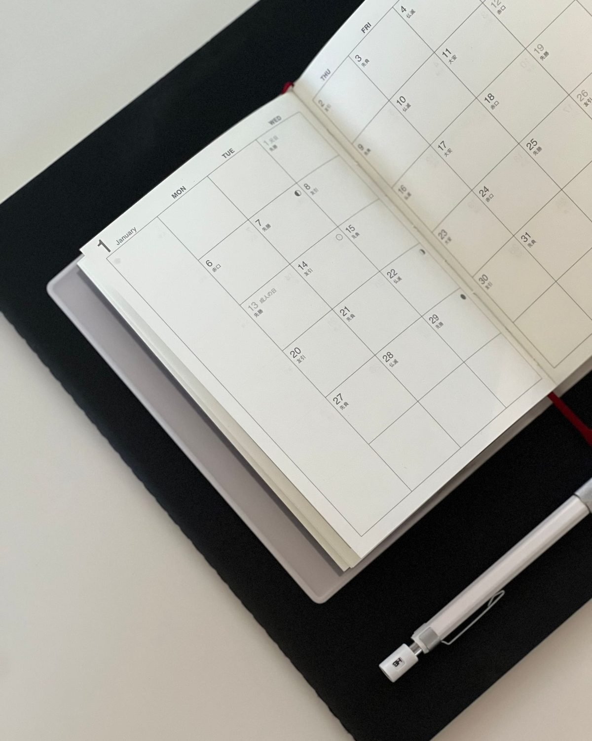 open planner calendar on a desk with a pen for planning a january organization challenge