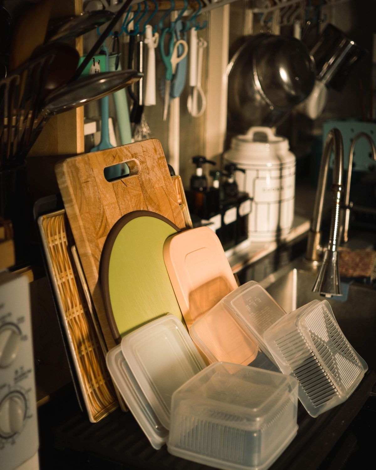 organized kitchen sink area with cutting boards stored upright and containers