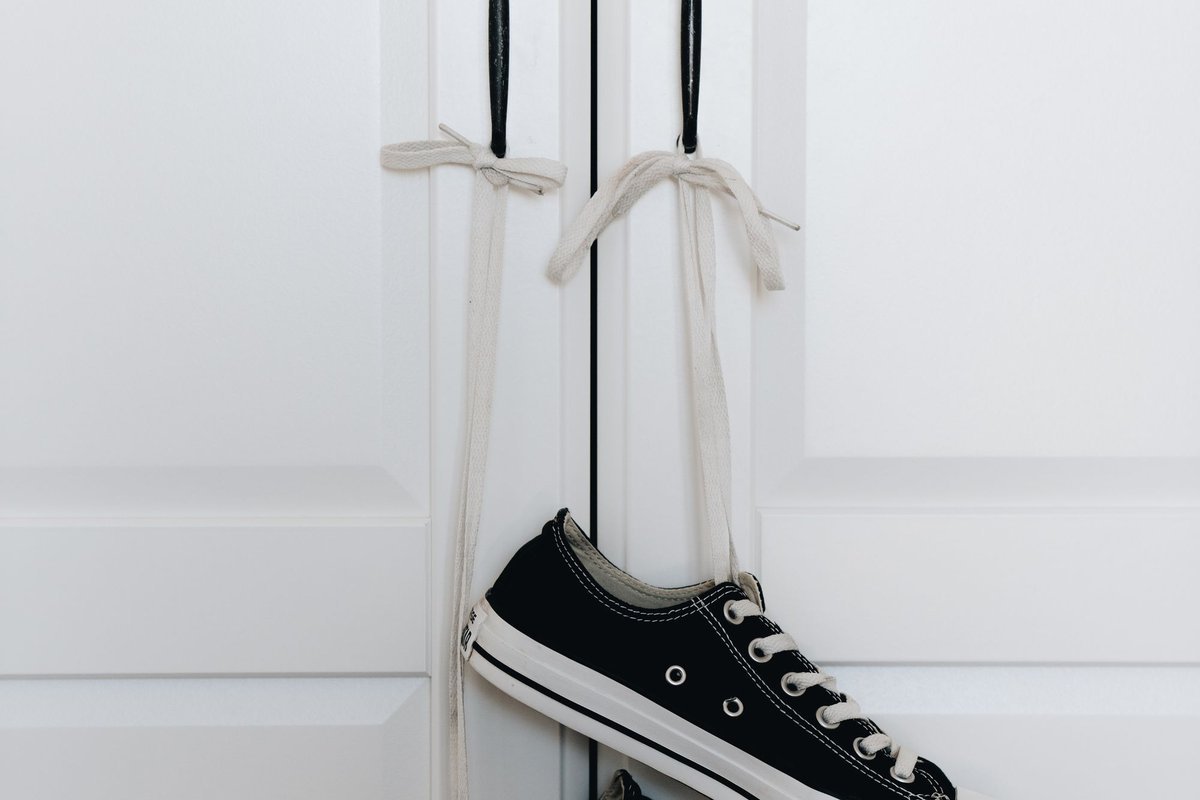 Sneakers hanging on a door handle to save floor space