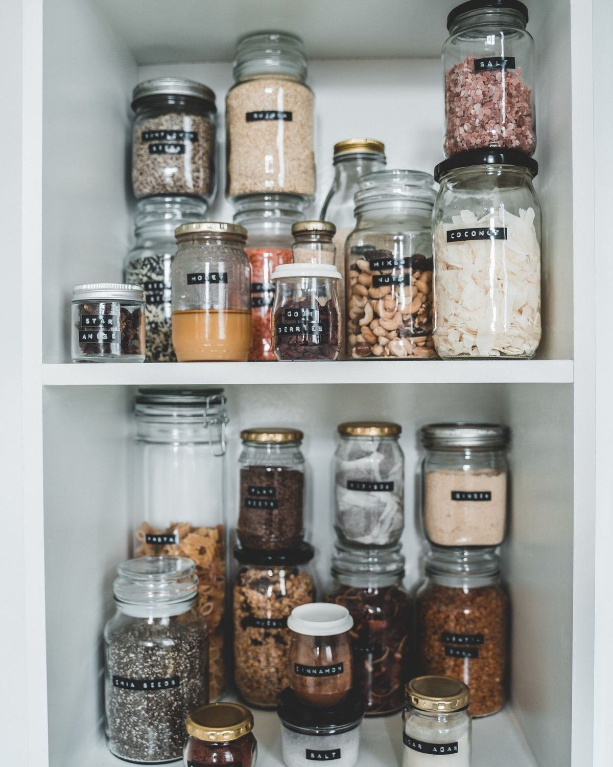 pantry shelf with glass jars of dry goods for budget kitchen organization