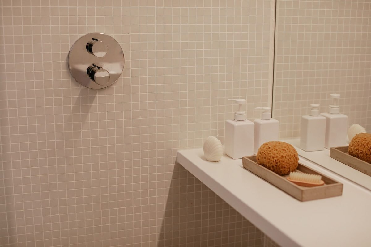 pump bottles and soap on a wooden tray on a bathroom ledge