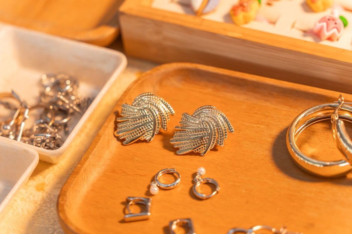 silver jewelry arranged on a small wooden tray
