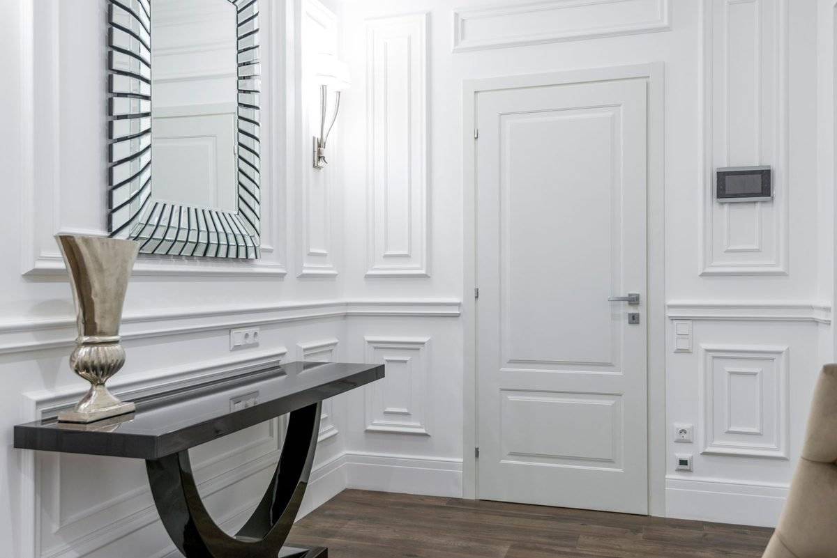 slim console table and mirror by the front door of an apartment