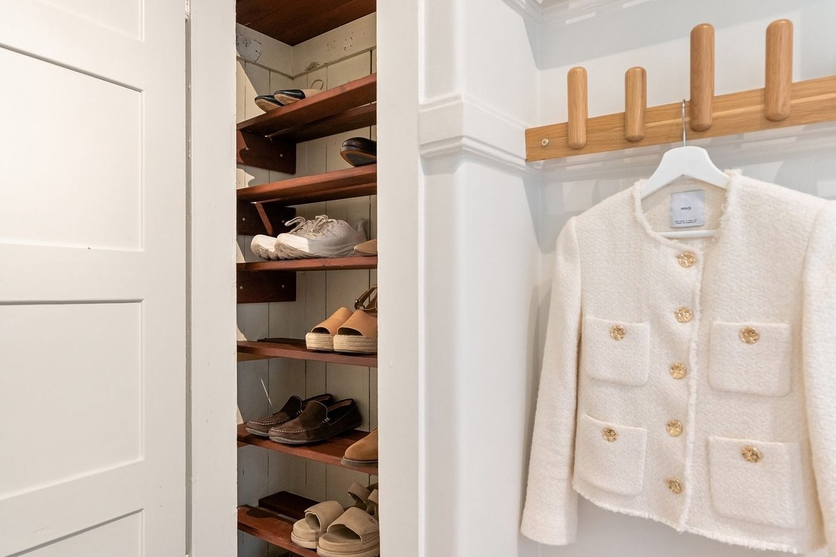 Open wardrobe with shoes lined up on slim shelves