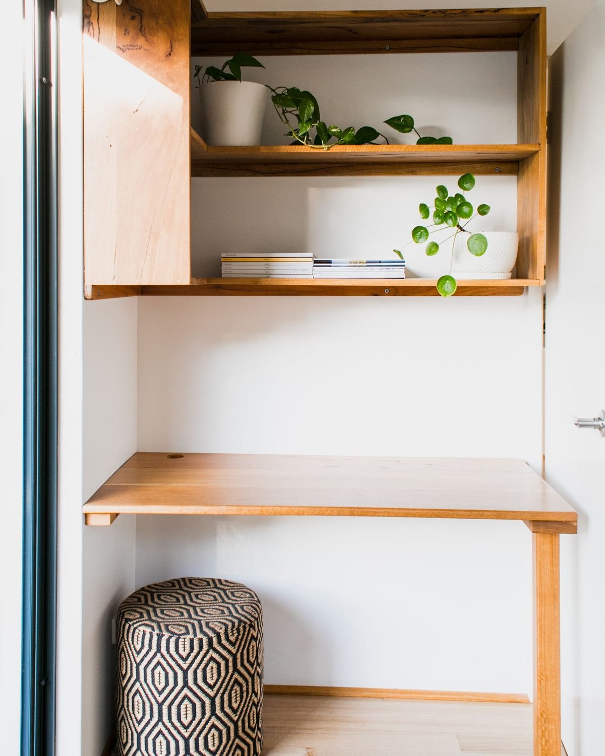 small apartment storage ideas for a studio with a wooden desk and wall shelves