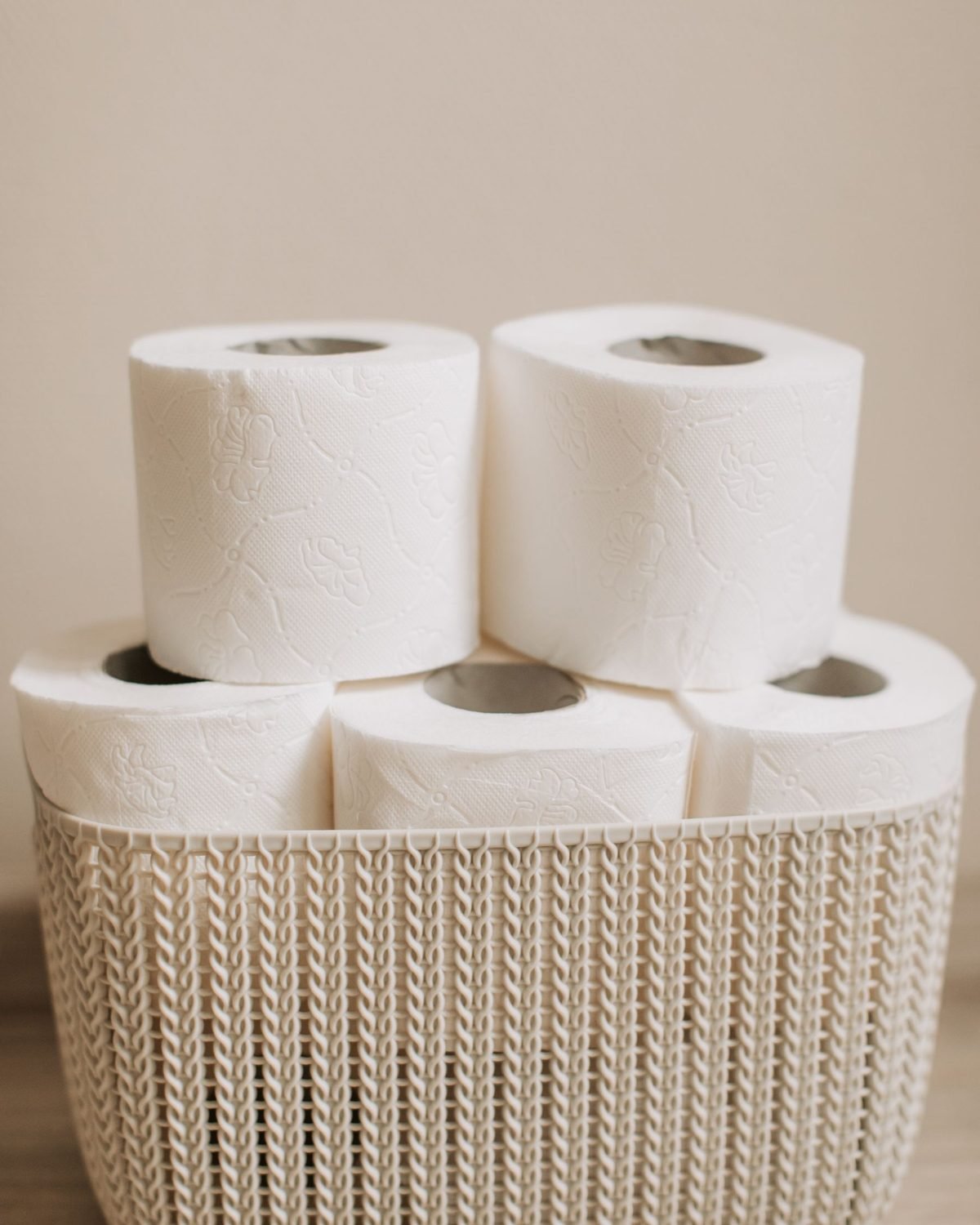 stack of toilet paper rolls stored in a basket