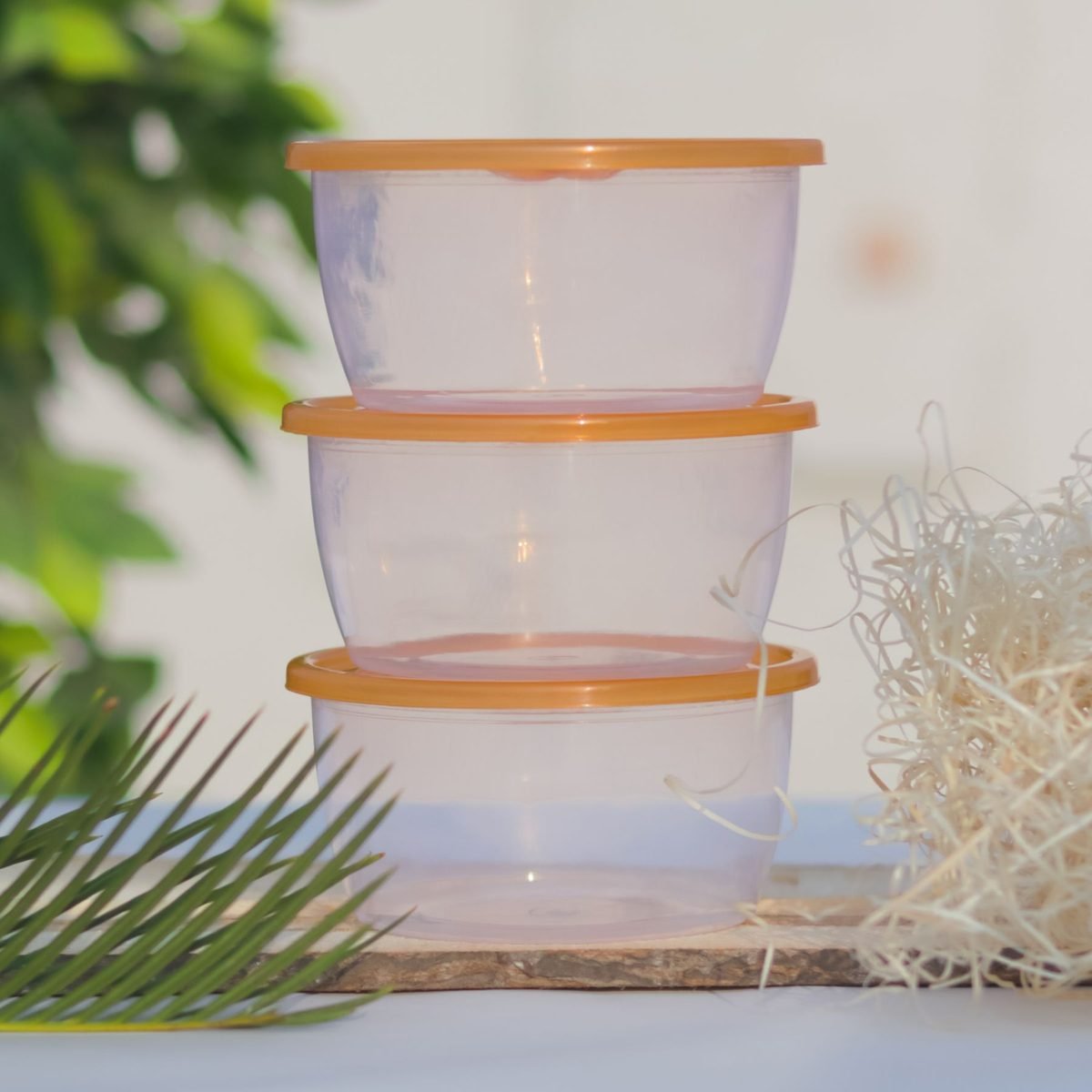 three stacked clear plastic food containers with orange lids