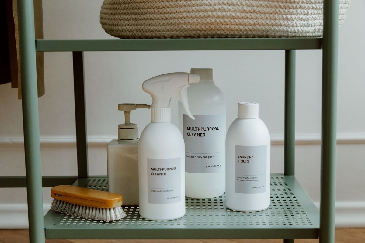 Cleaning spray bottles organized on a metal shelf