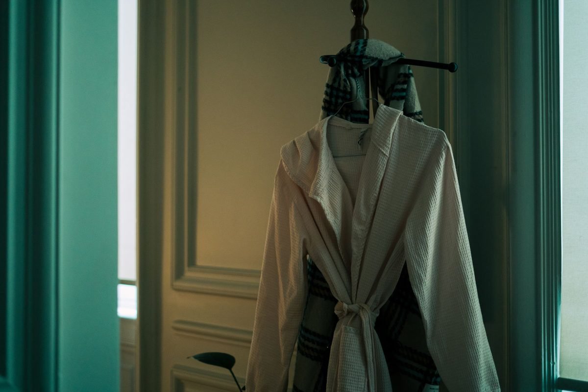 white bathrobe hanging on a hook on the back of a door