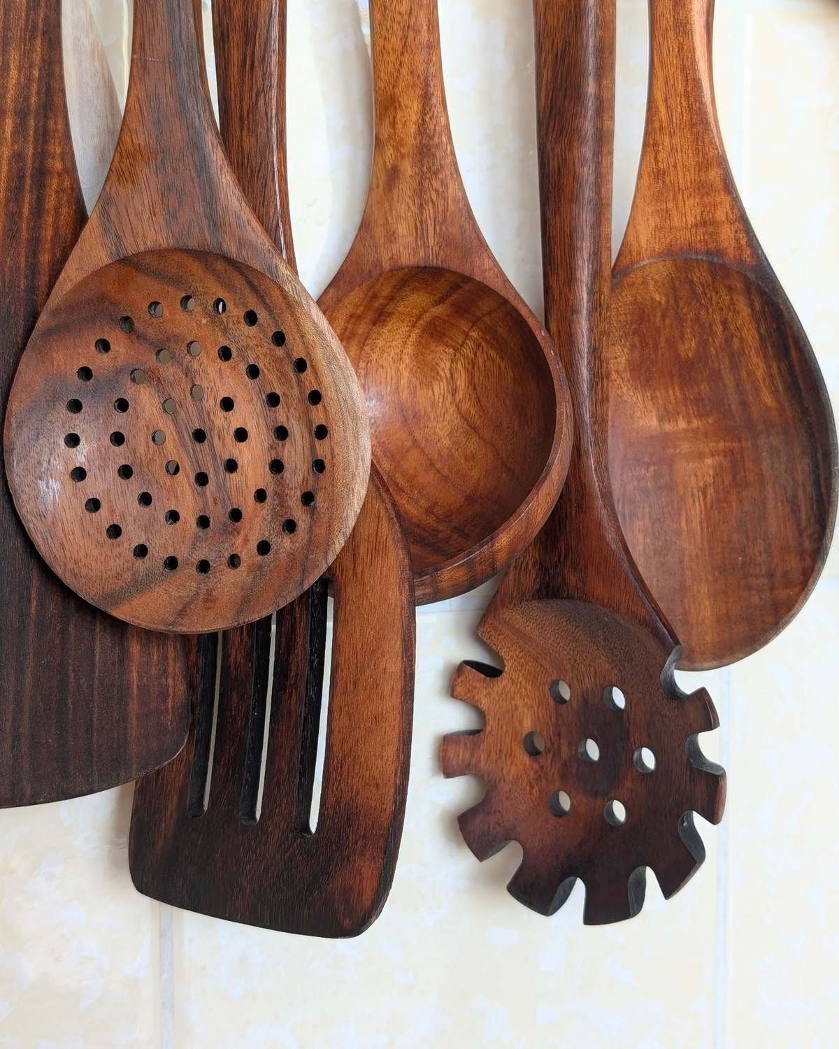 wooden kitchen utensils hanging against a kitchen wall