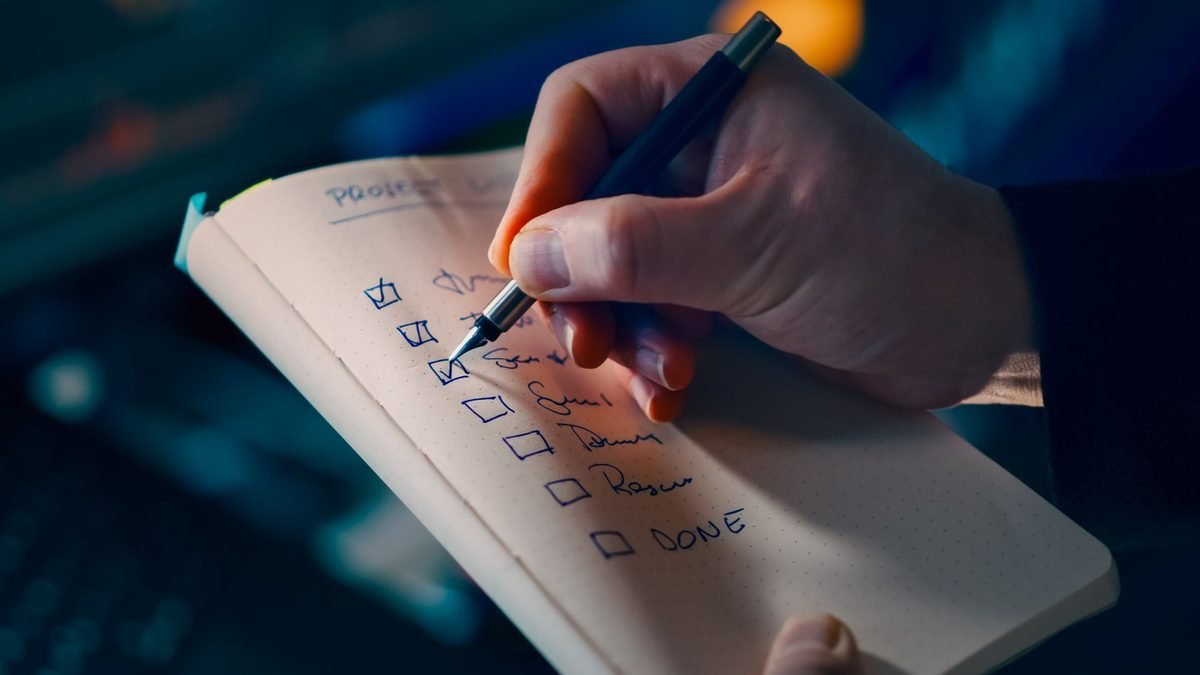 hand writing a checklist in a notebook